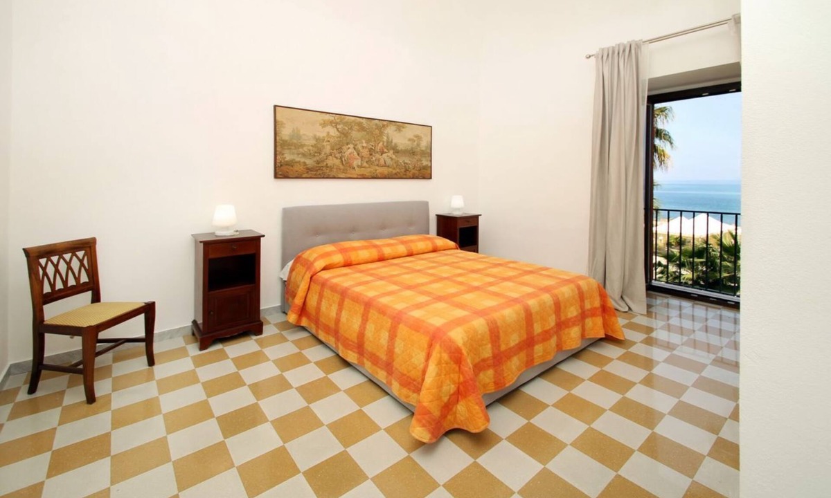 Marina di Caronia Apartment | Dimora Burrafato, known by locals as “La Casa Rossa”, is a historic summer residence once owned by Princess Pignatelli, located directly on the seafront of Caronia. The property consists of three independent units, each with a private entrance, a bal