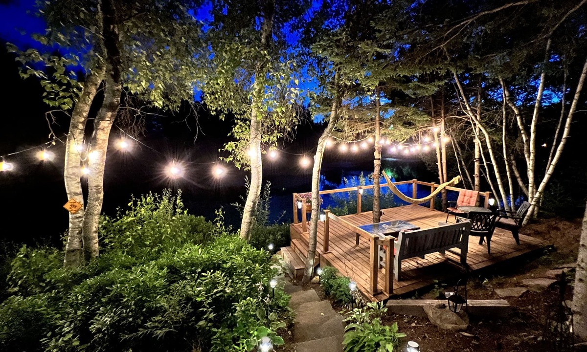 Cap-Pele Ski Chalet | Luxurious secluded rustic wooden chalet on edge of tranquil pond next to beach.