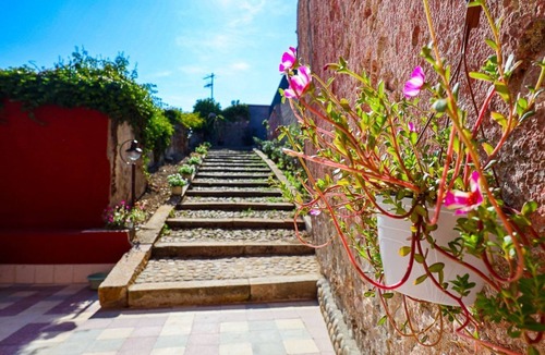 Marina di Caronia Apartment | Dimora Burrafato, known by locals as “La Casa Rossa”, is a historic summer residence once owned by Princess Pignatelli, located directly on the seafront of Caronia. The property consists of three independent units, each with a private entrance, a bal