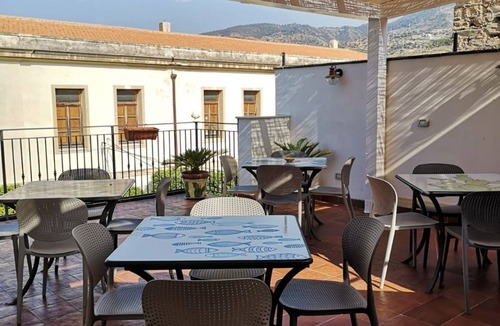 Santo Stefano di Camastra Apartment | Salvia is an independent loft located on the ground floor, featuring a small private courtyard furnished with chairs and a table. The space consists of an open-plan area with a sofa bed and equipped kitchen, as well as a spacious bathroom with a shower.