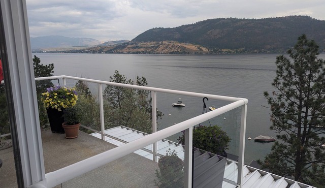 Penthouse Condo with amazing OK lake and mountain views, private beach and dock.